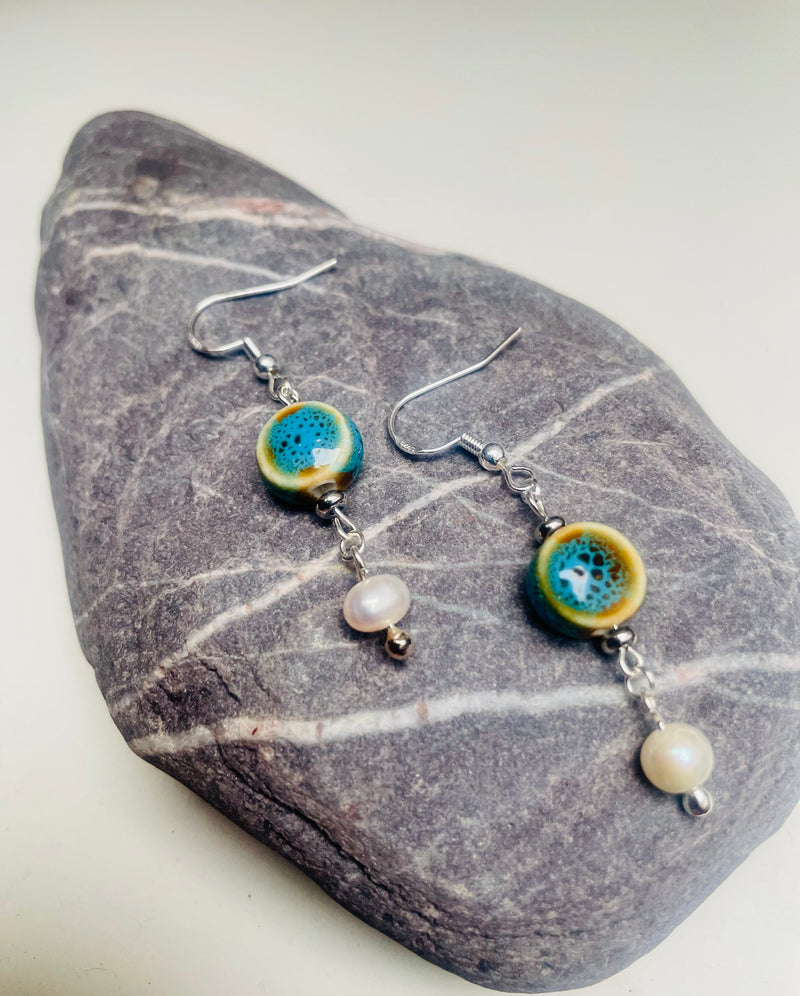 Handmade MAYIA earrings with blue ceramic bead and pearl on sterling silver hooks.